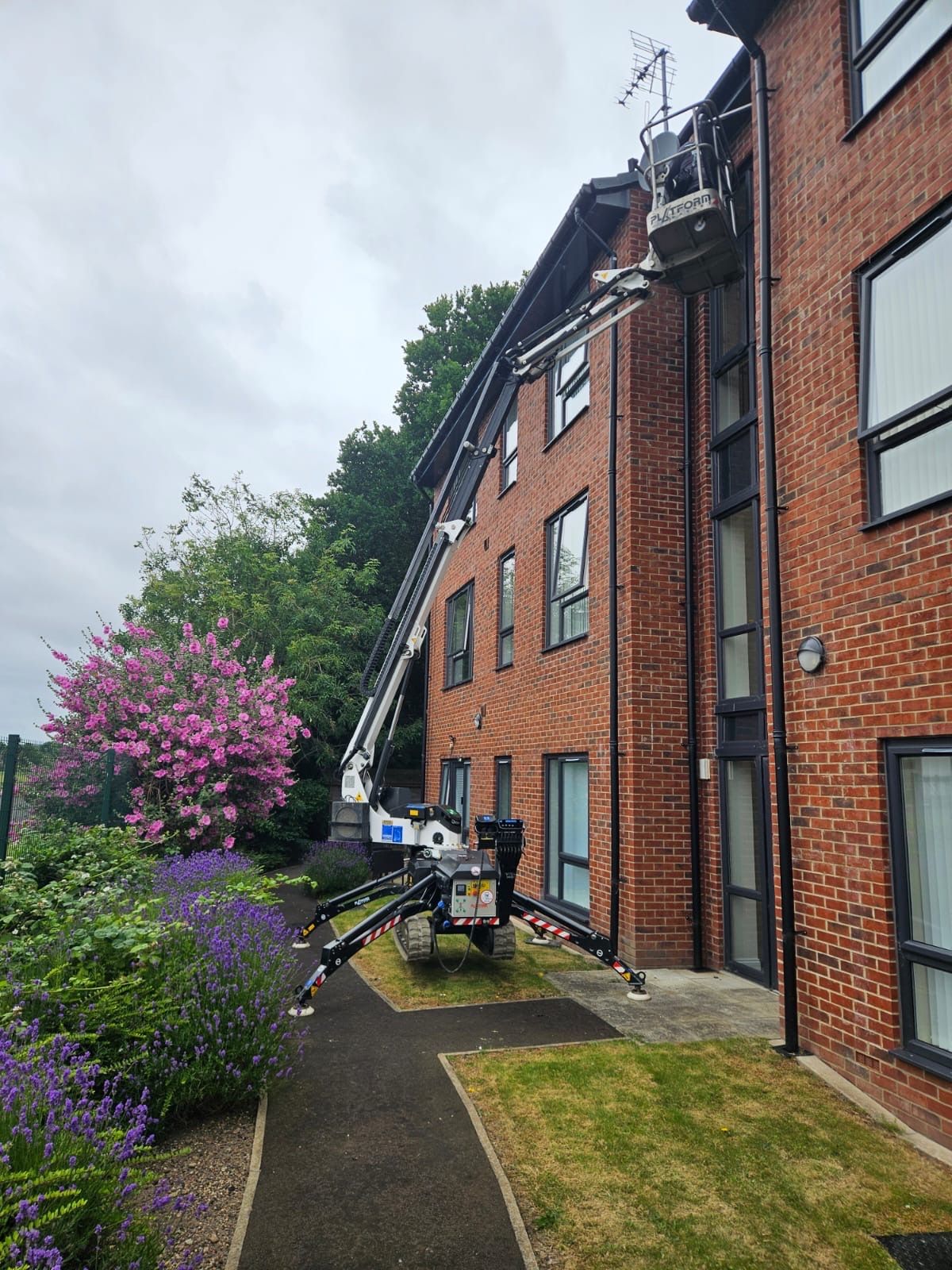 Spider platform deployed in garden against block of flats