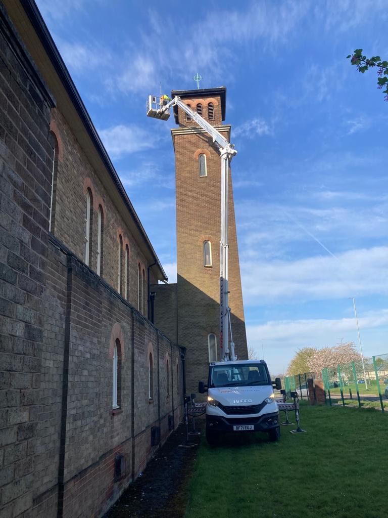 ProClean Access cherry picker reaching top of tall church tower