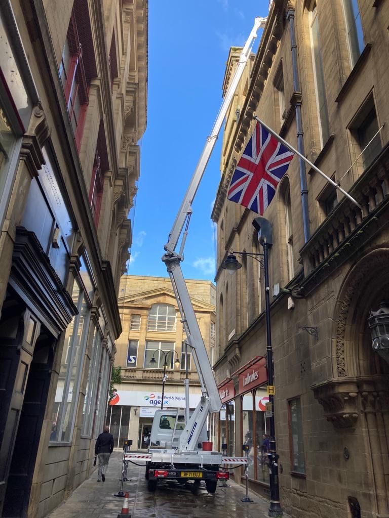 Cherry picker in narrow Bradford town centre street between Victorian buildings