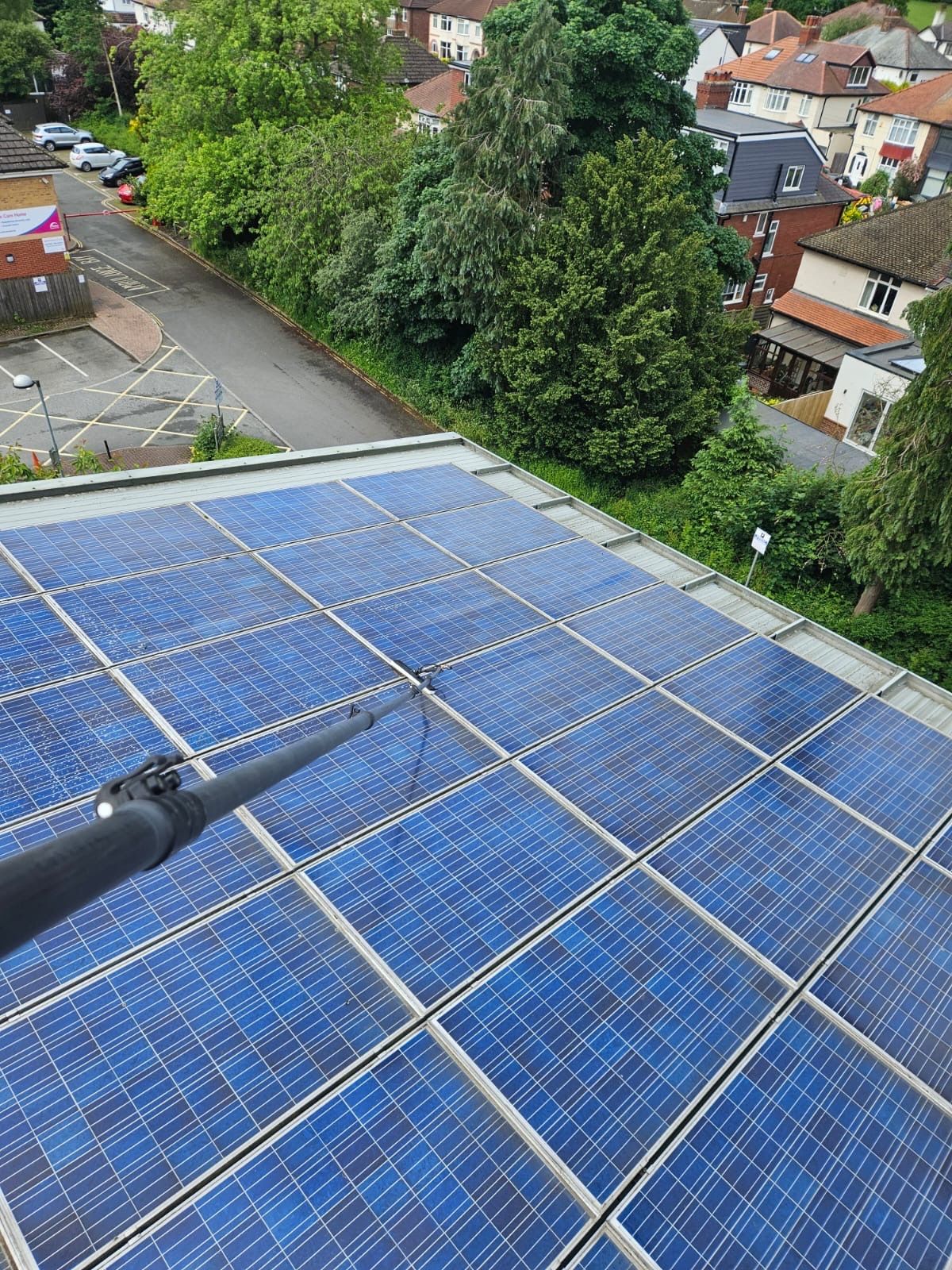 Solar panels on care home roof being cleaned from access platform