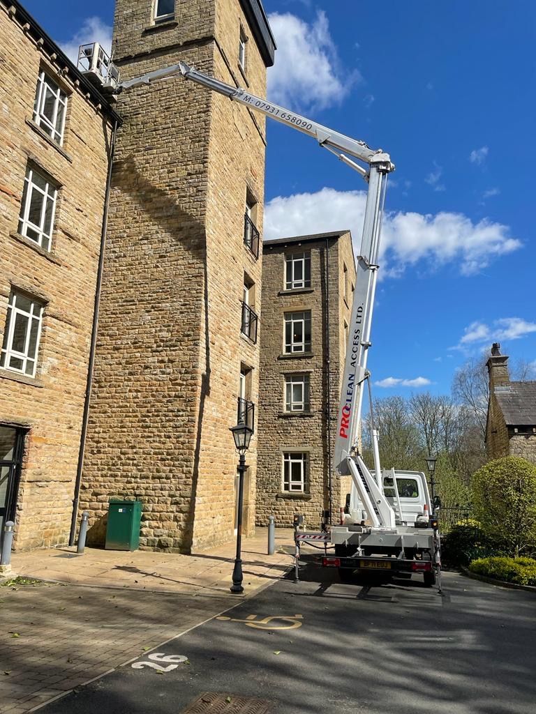 ProClean Access cherry picker reaching the top of a stone mill building in Yorkshire