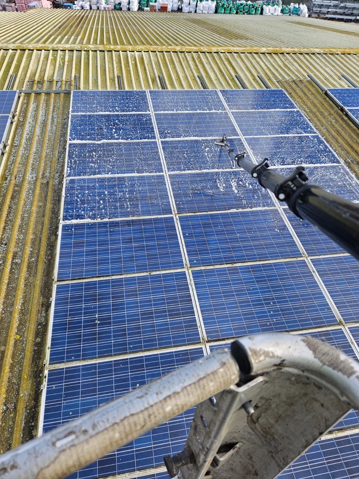 Close-up of dirty solar panels being cleaned with specialist soft brush equipment